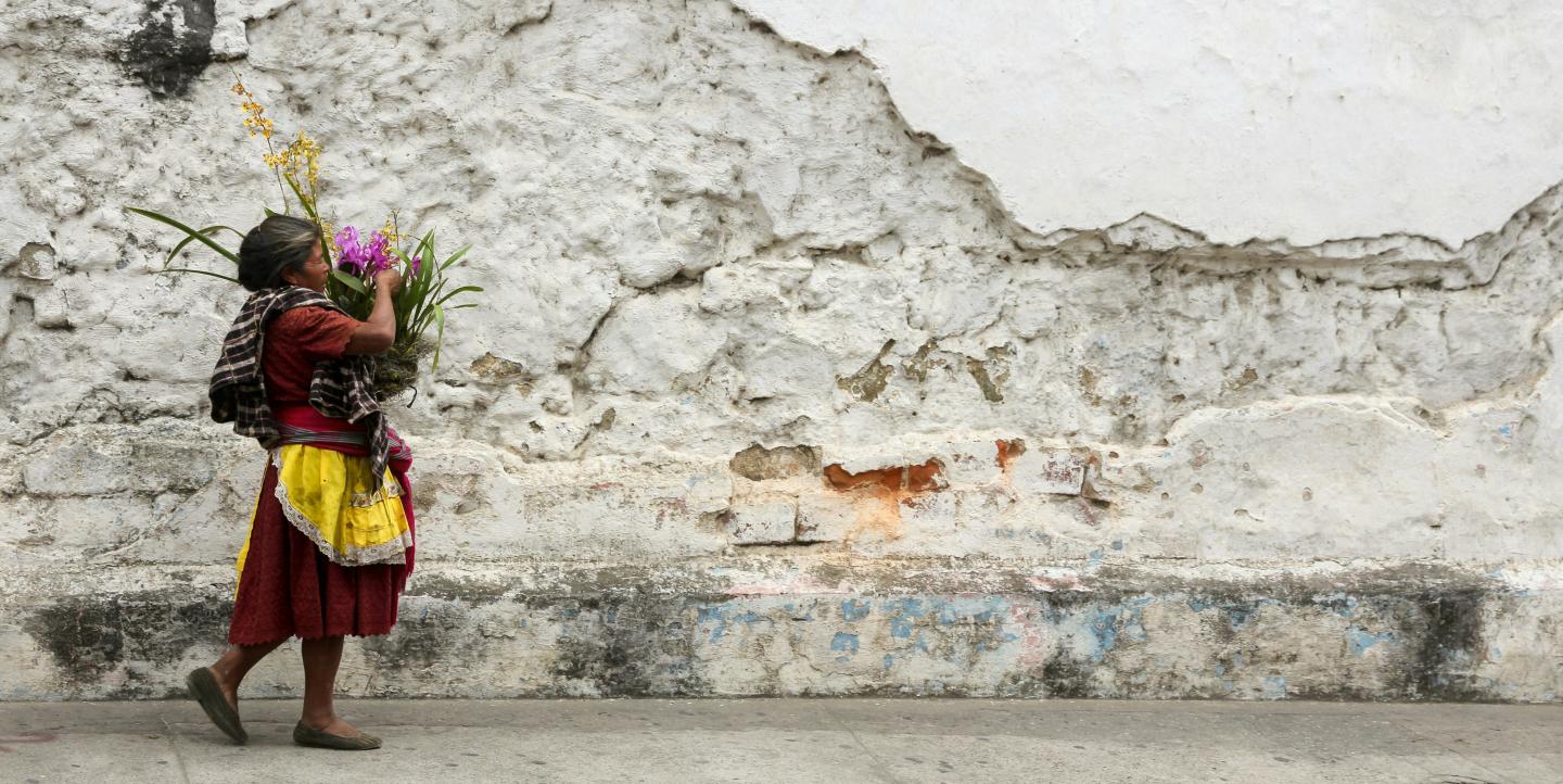 Une femme autochtone porte un bouquet de fleurs à Antigua, au Guatemala.